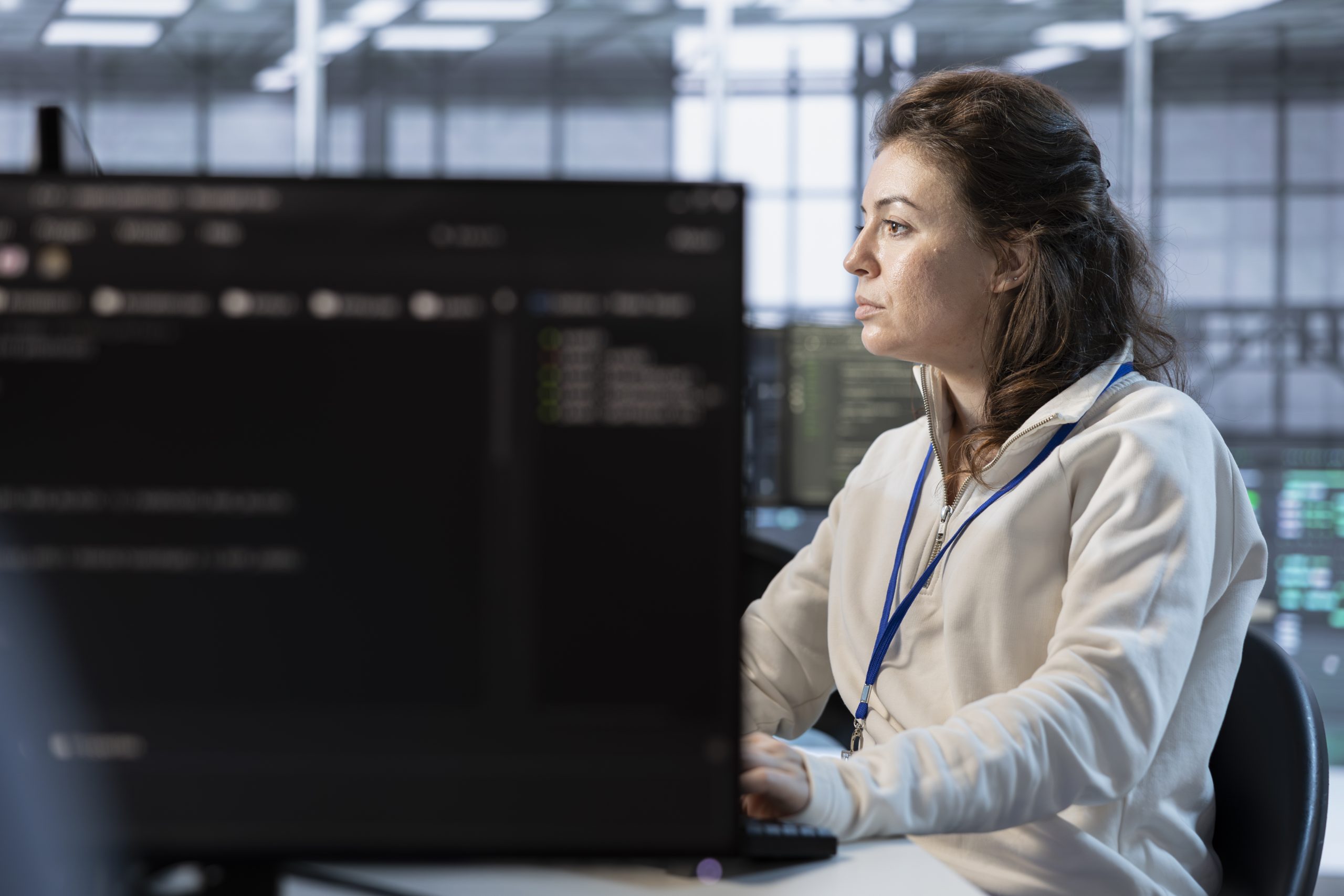 IT support specialist at workstation wearing headphones with microphone.